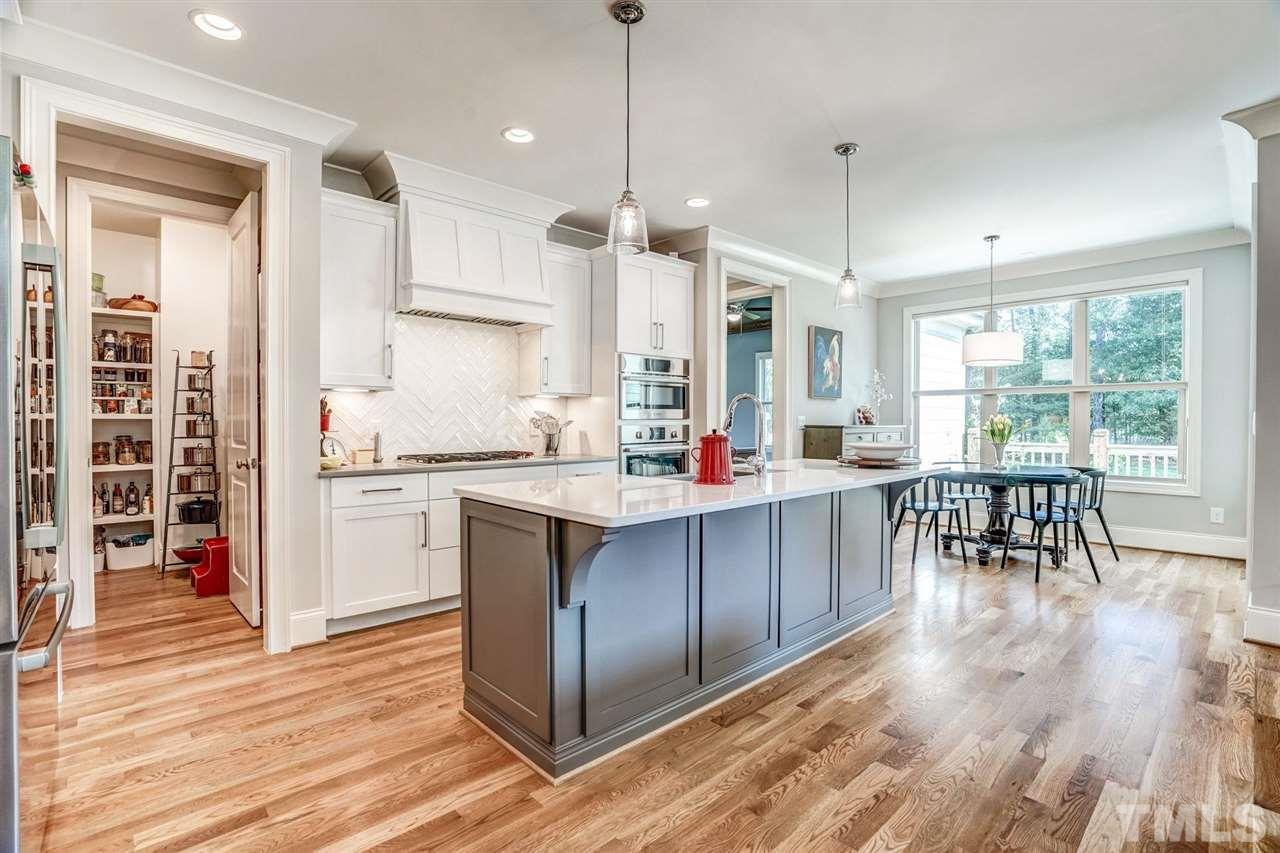 14010 Durant Road Raleigh, NC 27614 - Photo 13 of 30 a kitchen with stainless steel appliances granite countertop a stove top oven a sink dishwasher and a dining table with wooden floor