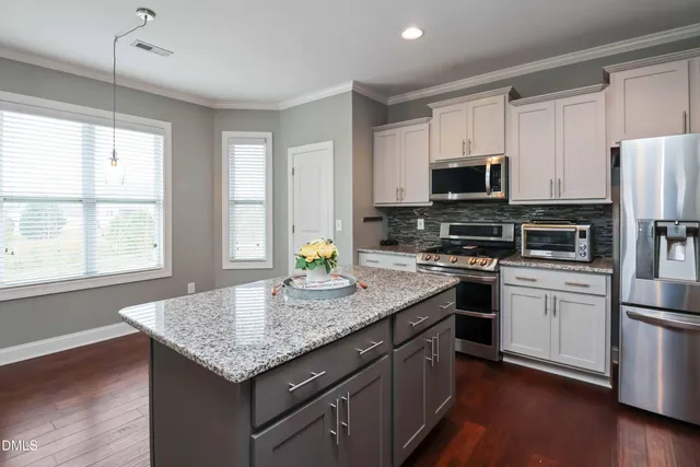 a view of an empty room with fire place and a window