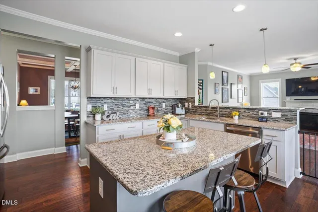 a kitchen with stainless steel appliances granite countertop a stove a refrigerator a sink a microwave and wooden floor