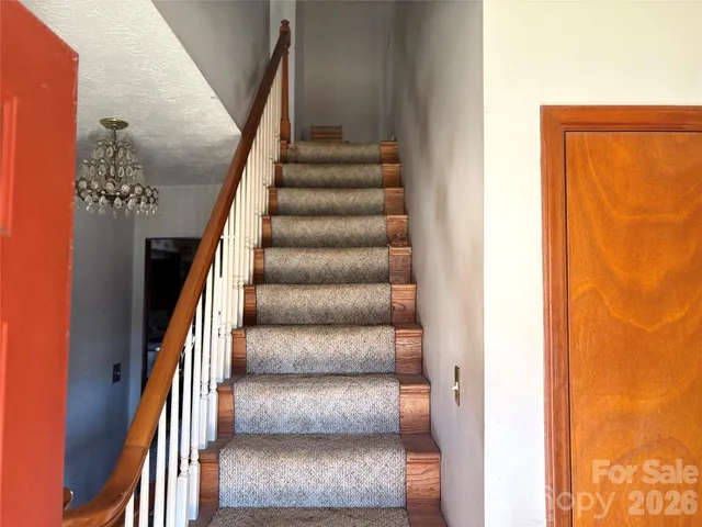 a view of a hallway with wooden floor and mirror