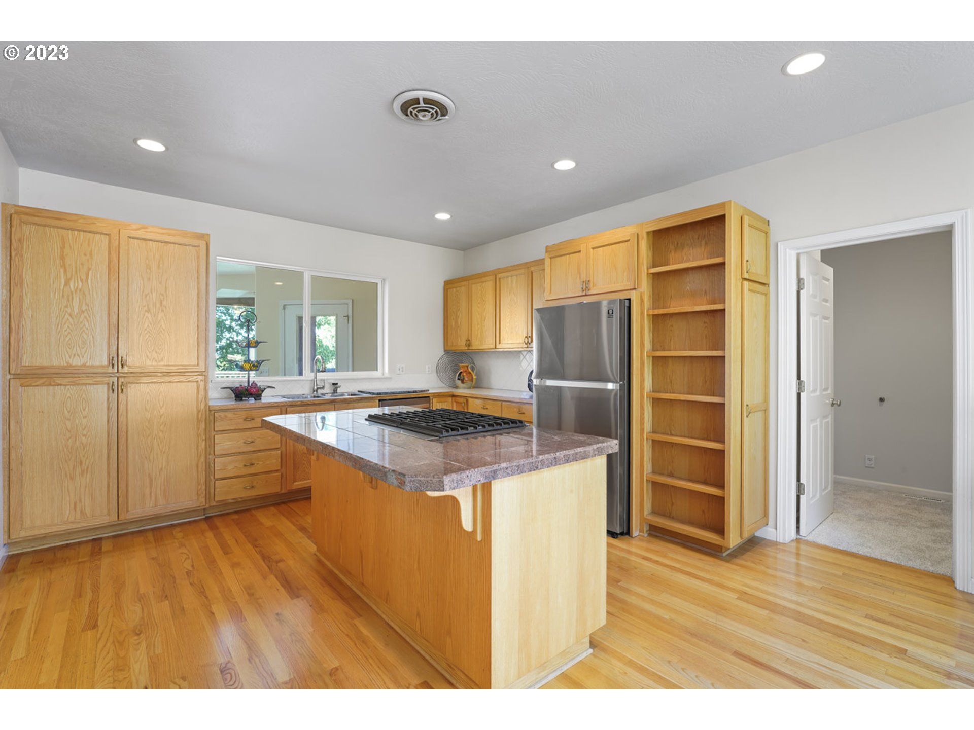 2920 Adams Street Eugene, OR 97405 - Photo 11 of 38 a kitchen with stainless steel appliances granite countertop a refrigerator a sink dishwasher and a stove with wooden floor