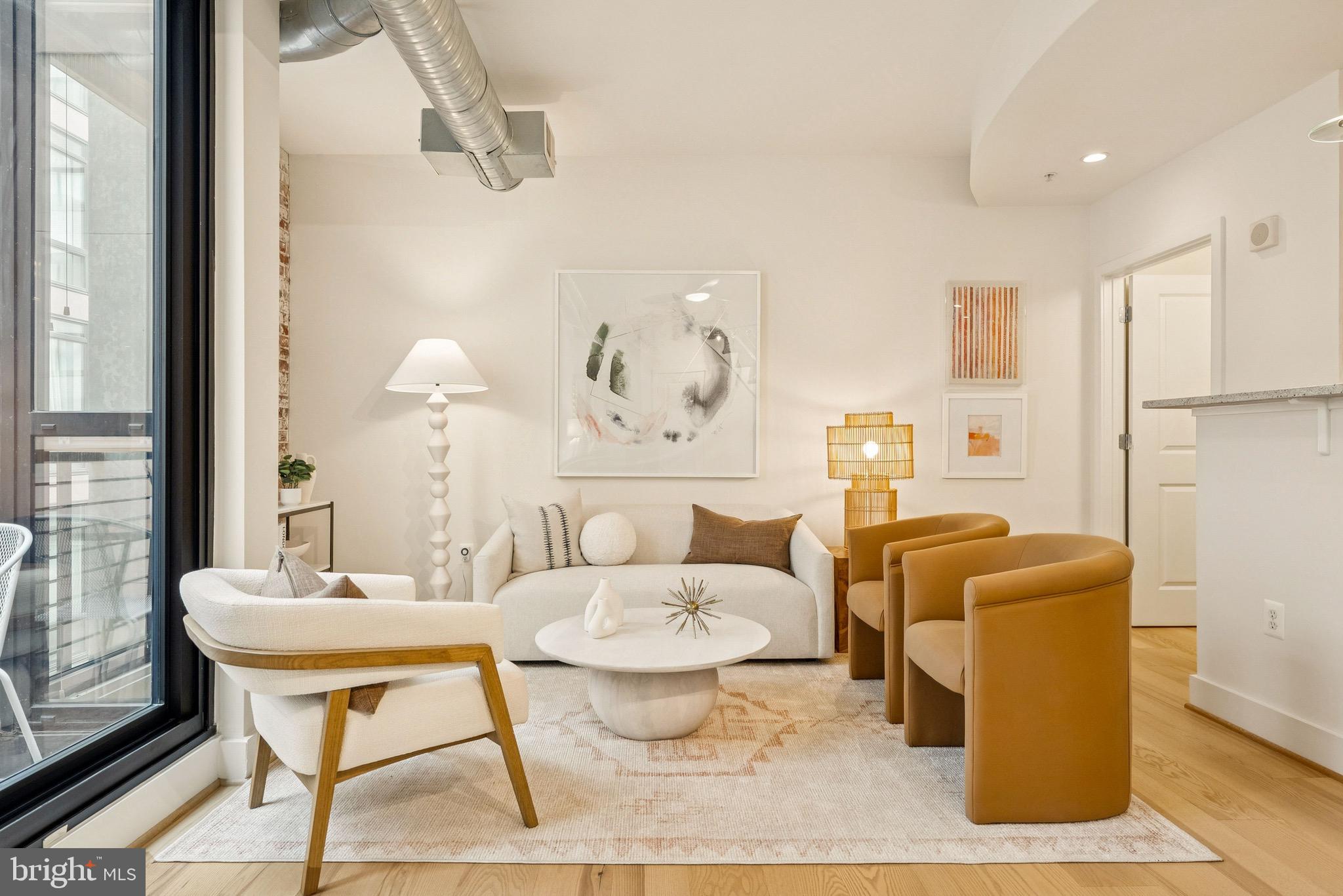 1209 13th Street Northwest, Unit 209 Washington, DC 20005 - Photo 2 of 16 a living room with furniture a table and a painting on the wall