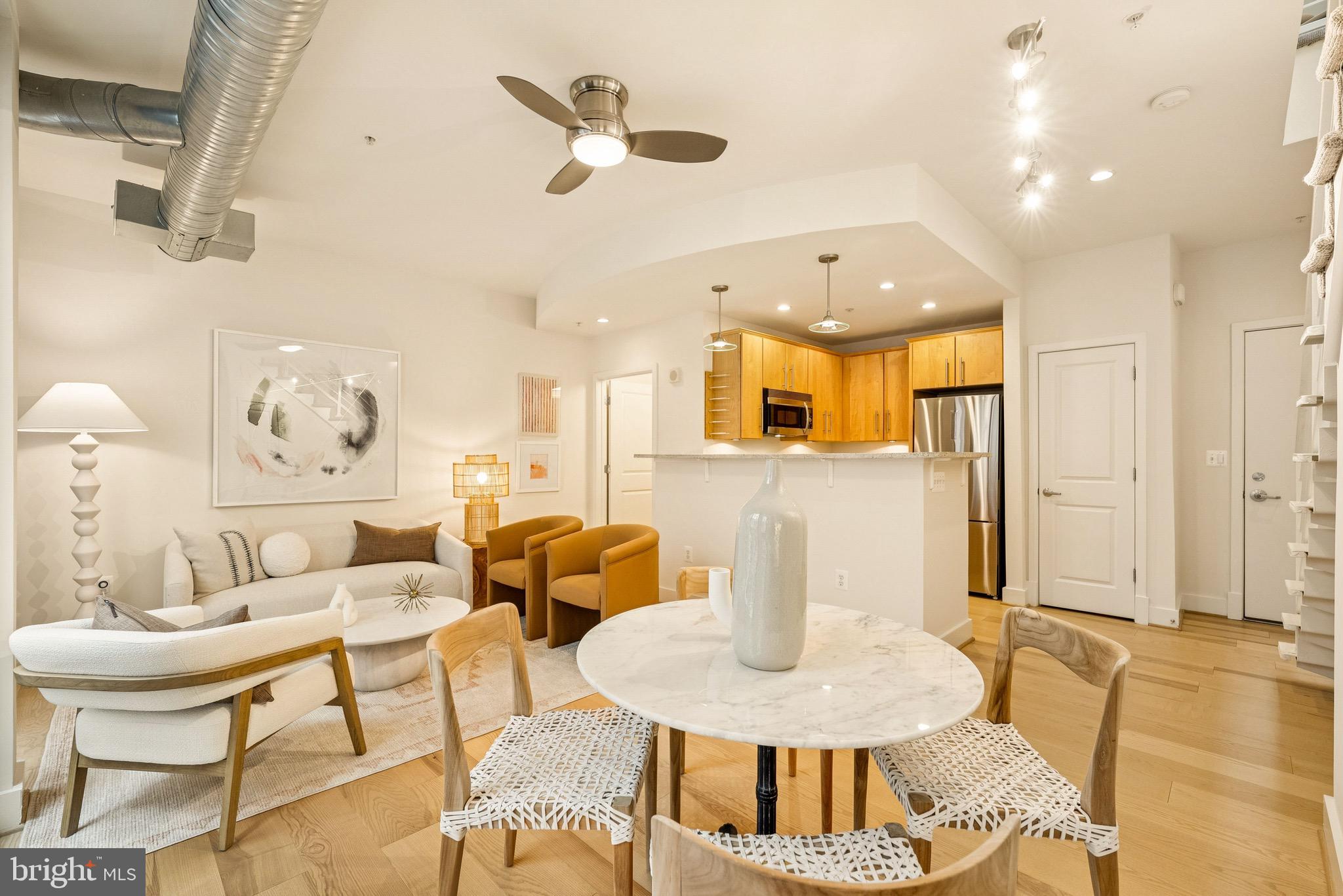 1209 13th Street Northwest, Unit 209 Washington, DC 20005 - Photo 7 of 16 a living room with kitchen island furniture and a view of kitchen