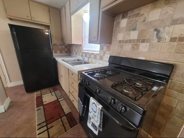 a kitchen with granite countertop a stove and a refrigerator