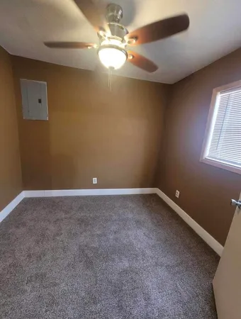 an empty room with windows and fan