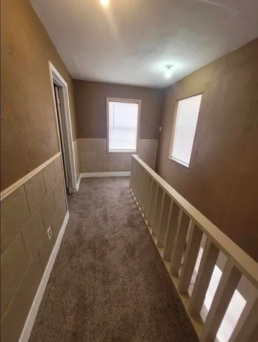 a view of hallway with window and stairs