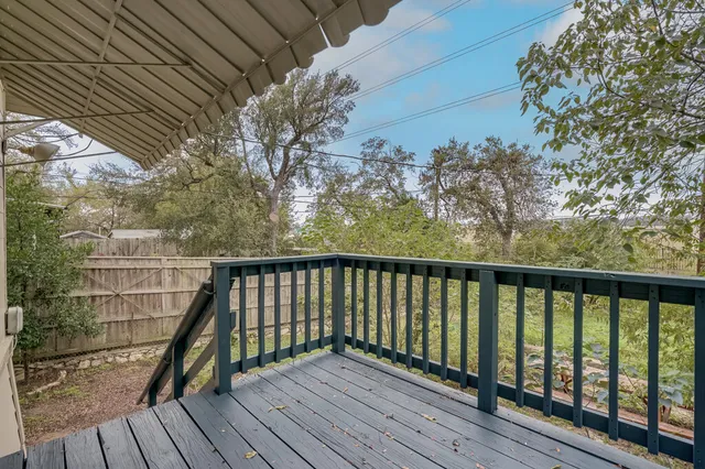 a view of balcony with wooden floor and fence
