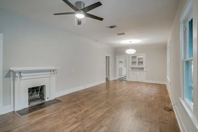 a view of empty room with wooden floor and fireplace
