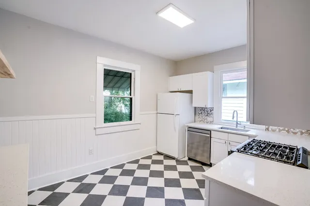 a kitchen with a checkered floor and a window