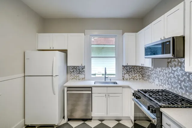 a kitchen with a refrigerator and a stove top oven