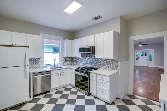 a kitchen with stainless steel appliances a stove a sink and a refrigerator