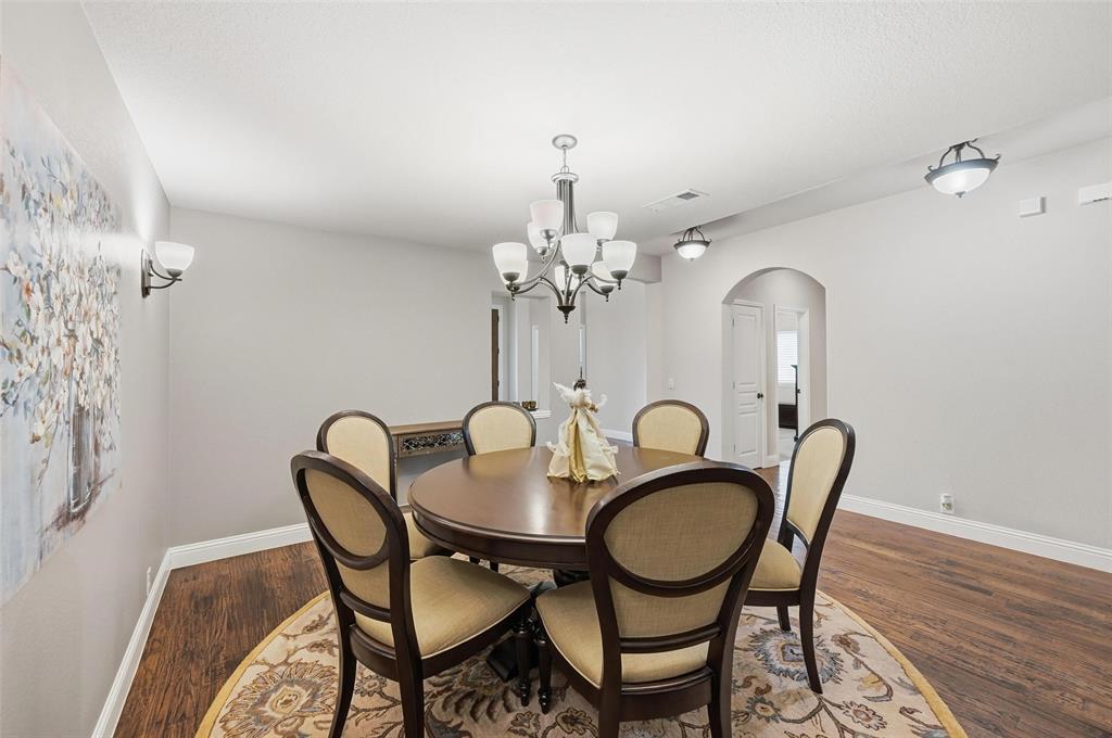 1421 Nighthawk Lane Mansfield, TX 76063 - Photo 6 of 40 a dining room with furniture a chandelier and wooden floor