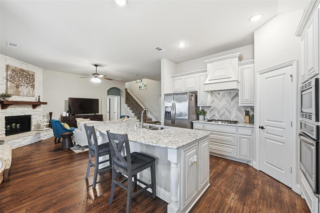 1421 Nighthawk Lane Mansfield, TX 76063 - Photo 7 of 40 a kitchen with stainless steel appliances granite countertop a stove a refrigerator a kitchen island with a stove and white cabinets