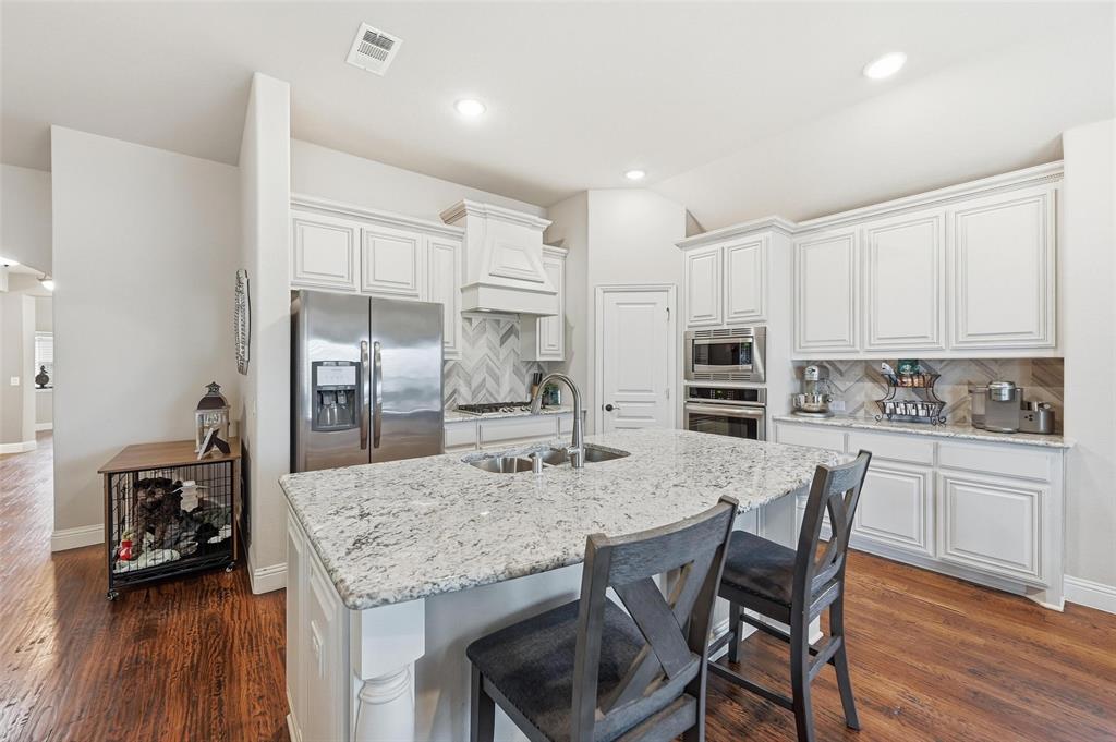 1421 Nighthawk Lane Mansfield, TX 76063 - Photo 8 of 40 a kitchen with stainless steel appliances granite countertop a stove refrigerator and cabinets