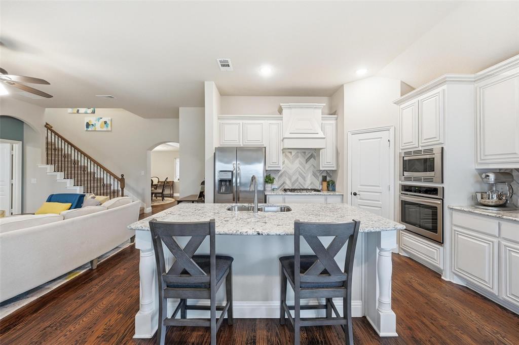 1421 Nighthawk Lane Mansfield, TX 76063 - Photo 9 of 40 a kitchen with stainless steel appliances a dining table chairs and wooden floor