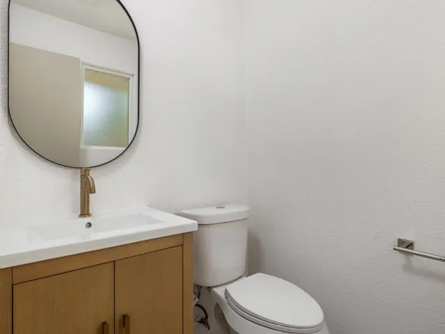 a bathroom with a toilet and mirror