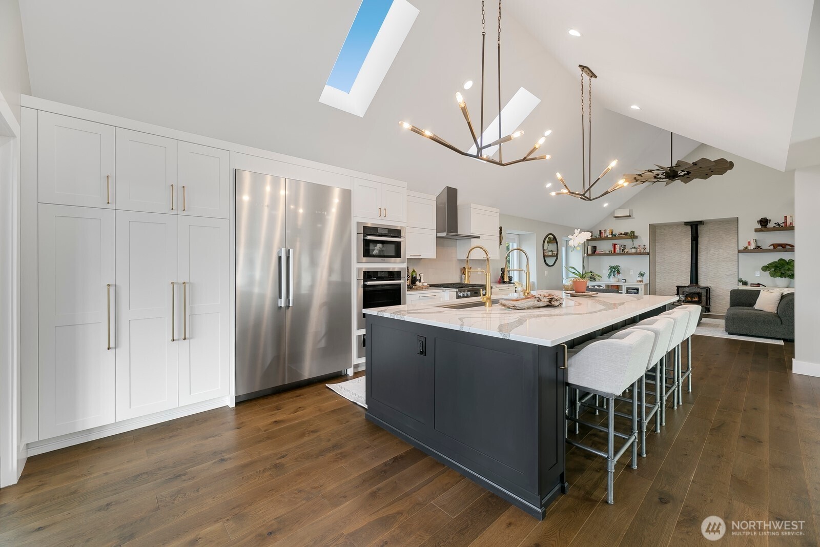 6625 136th Place Southwest Edmonds, WA 98026 - Photo 10 of 40 a kitchen with stainless steel appliances granite countertop a refrigerator a sink dishwasher a stove and a dining table with wooden floor