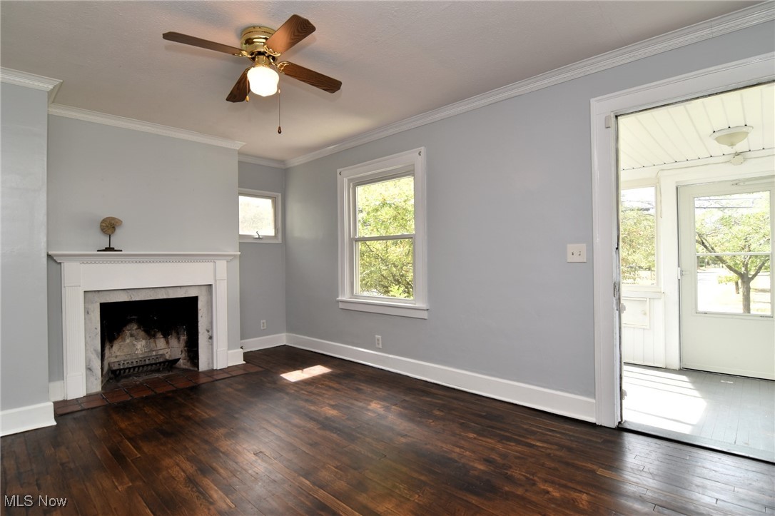 1683 Sunview Road Cleveland, OH 44124 - Photo 2 of 35 Unfurnished living room with ceiling fan, crown molding, dark wood-type flooring, and a high end fireplace