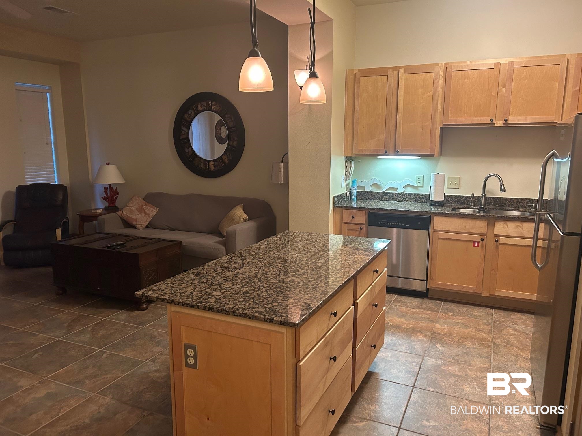 1430 Regency Road, Unit J102 Gulf Shores, AL 36542 - Photo 4 of 11 Kitchen with appliances with stainless steel finishes, light brown cabinets, dark stone counters, sink, and hanging light fixtures