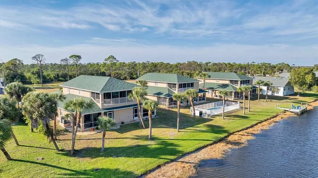 an aerial view of residential houses with outdoor space and trees