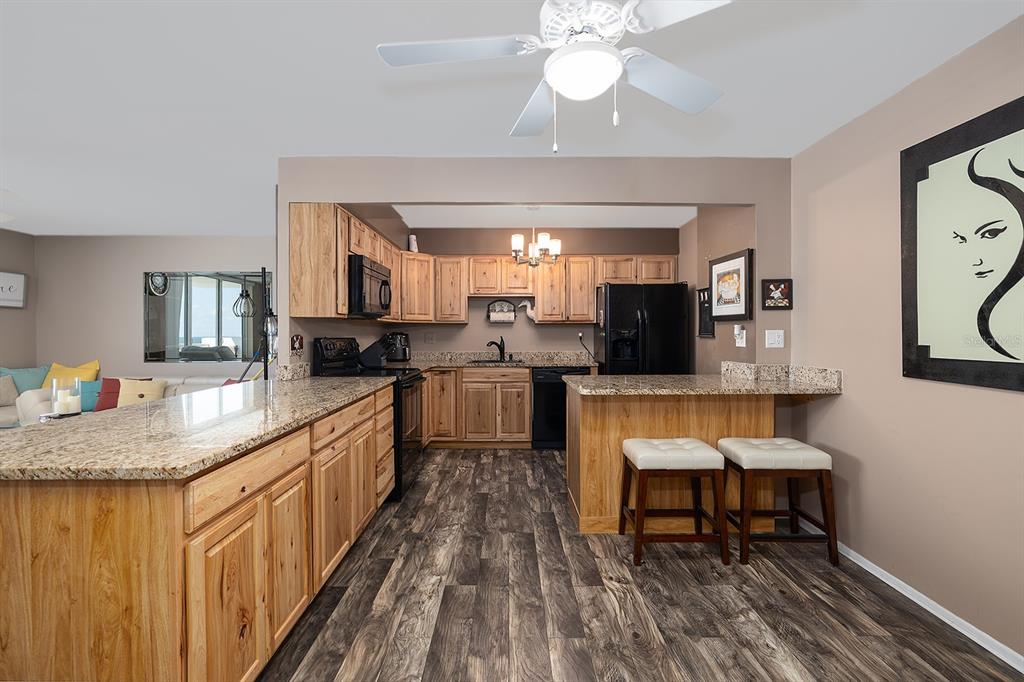 2800 North Atlantic Avenue, Unit 712 Daytona Beach, FL 32118 - Photo 10 of 20 a kitchen with stainless steel appliances granite countertop a sink and stove