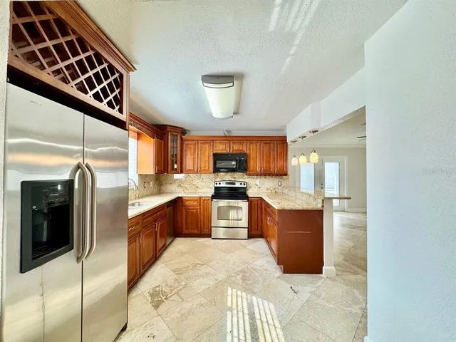 a kitchen with stainless steel appliances kitchen island granite countertop a refrigerator and stove