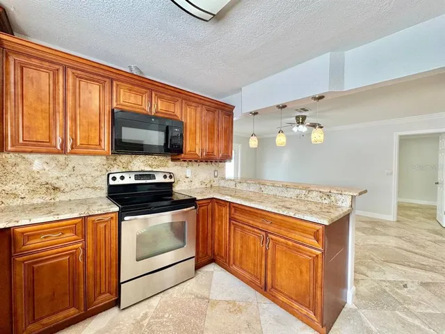 a kitchen with granite countertop cabinets stainless steel appliances and a counter space