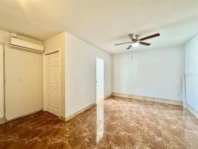 a living room with a stove and a ceiling fan