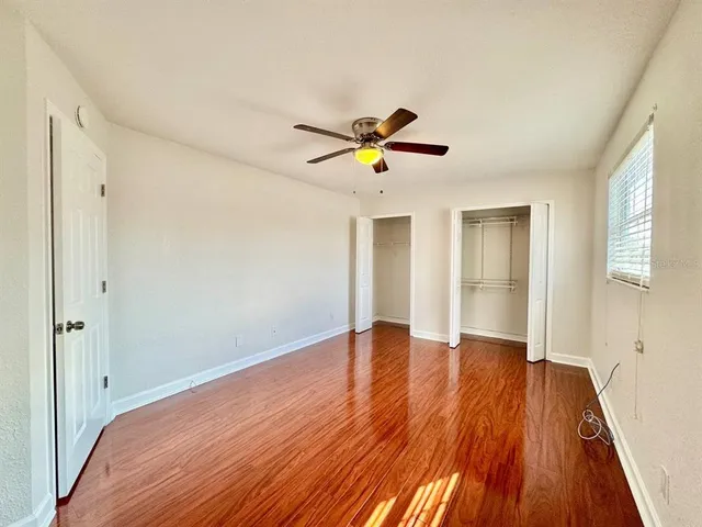 a view of a big room with wooden floor and a ceiling fan