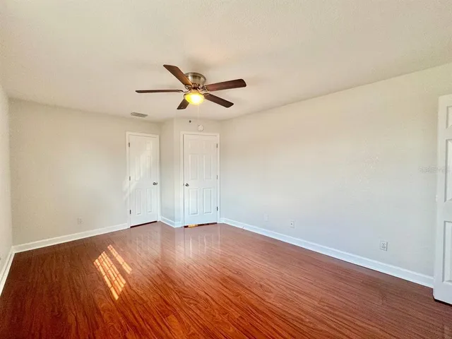a bathroom with a granite countertop double vanity sink a mirror and a bathtub