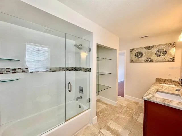 an empty room with wooden floor ceiling fan