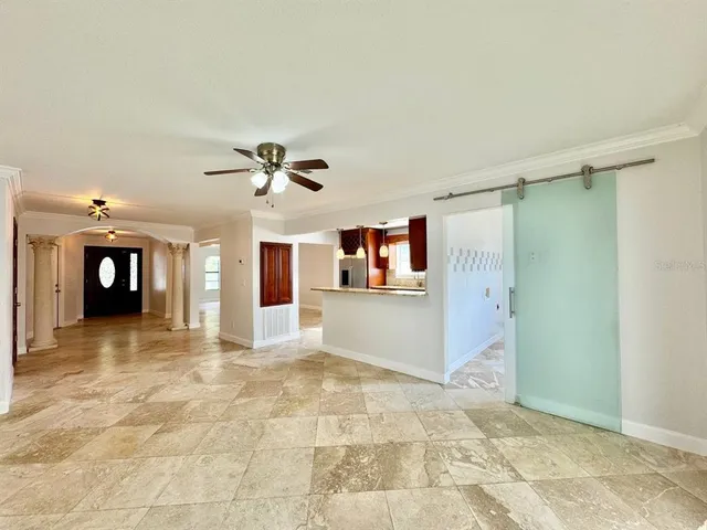 a view of a livingroom with wooden floor and a ceiling fan