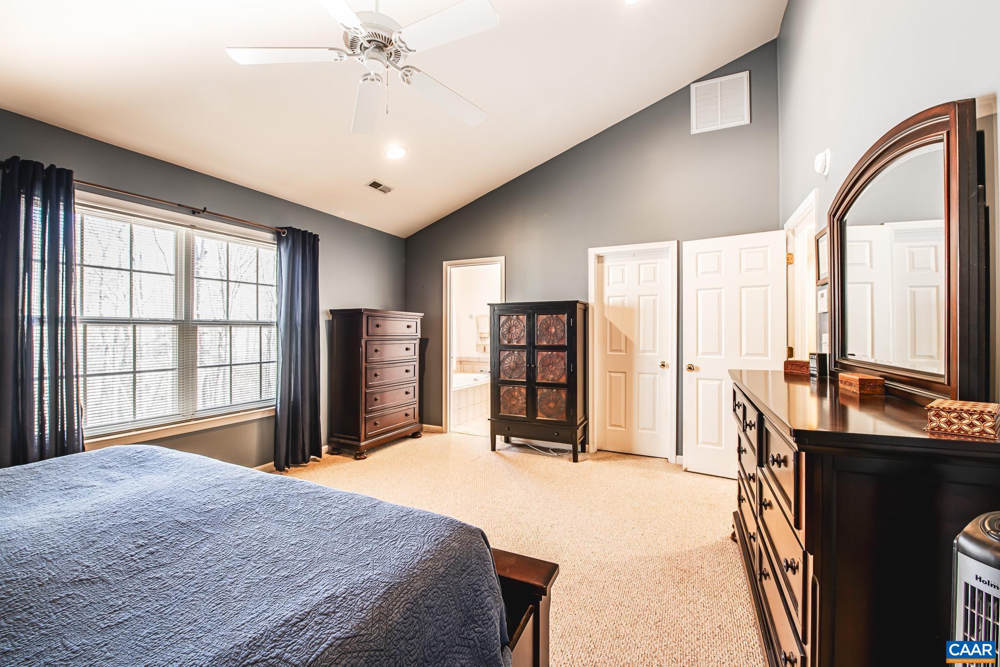116 Riverside Drive Palmyra, VA 22963 - Photo 16 of 31 a bedroom with a large bed and a chandelier