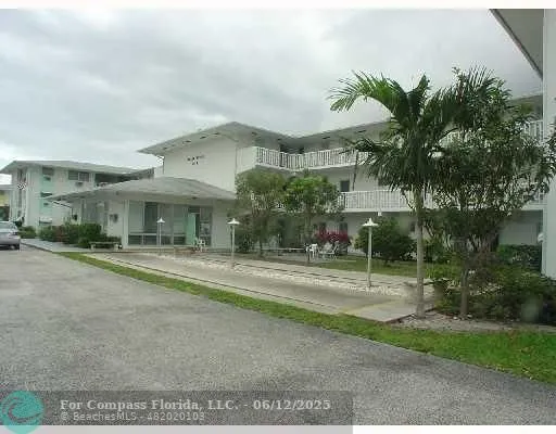 a front view of a house with a yard and potted plants