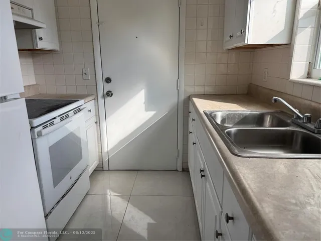 a view of a kitchen with white cabinets