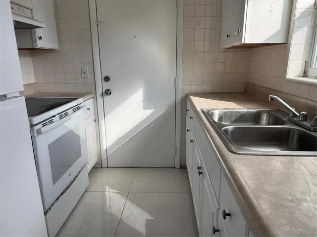 a view of a kitchen with white cabinets