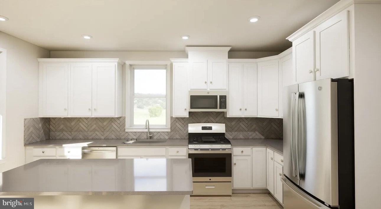 43312 Farringdon Square, Unit 215 Ashburn, VA 20148 - Photo 3 of 10 a kitchen with stainless steel appliances a refrigerator sink and microwave
