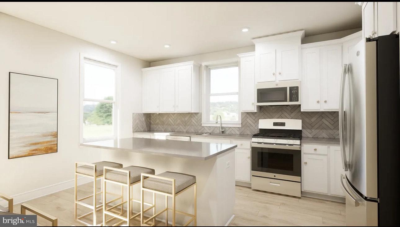 43312 Farringdon Square, Unit 215 Ashburn, VA 20148 - Photo 4 of 10 a kitchen with a stove a sink and a refrigerator