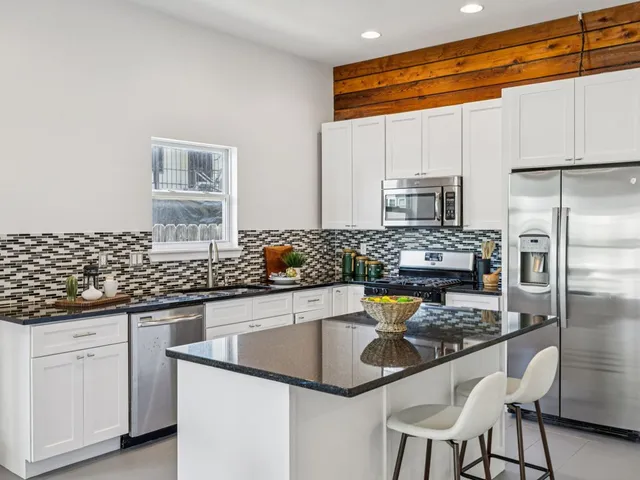 a kitchen with stainless steel appliances granite countertop a sink and cabinets