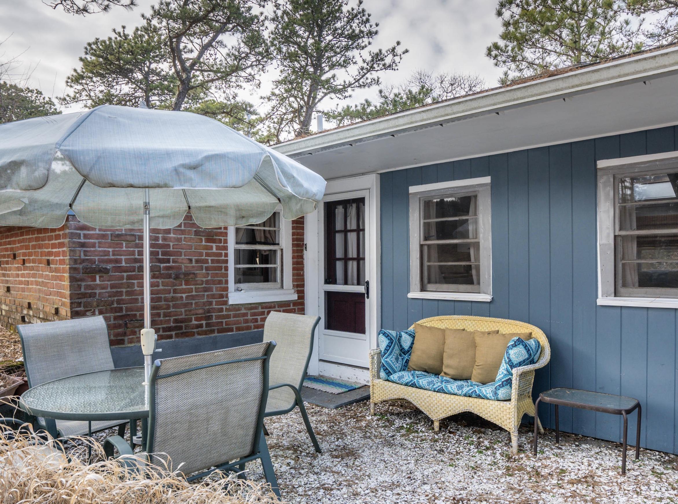 15 Massasoit Road Wellfleet, MA 02667 - Photo 5 of 23 a backyard of a house with table and chairs
