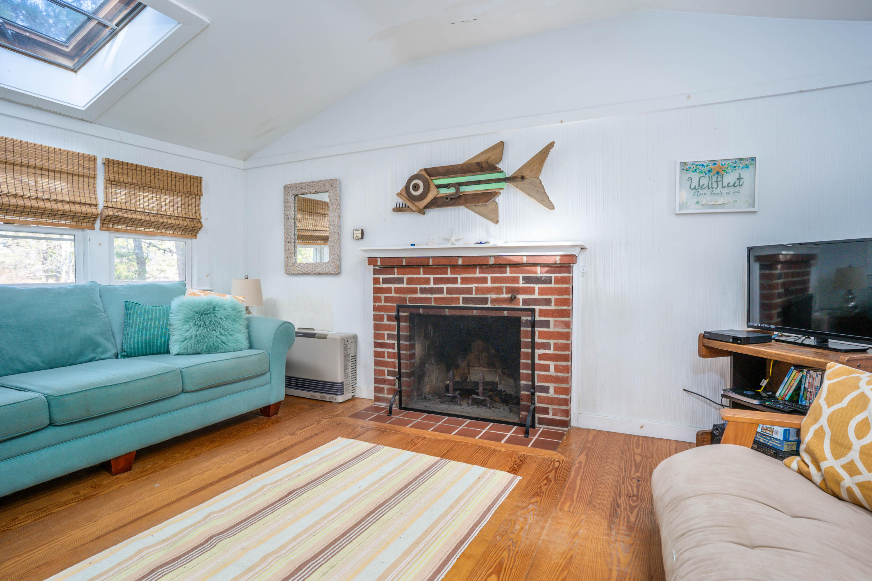 15 Massasoit Road Wellfleet, MA 02667 - Photo 8 of 23 a living room with furniture a flat screen tv and a fireplace