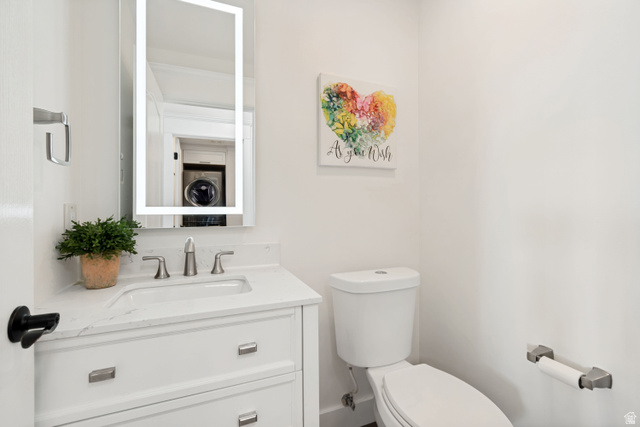 1567 Ridgeview Circle Farmington, UT 84025 - Photo 30 of 55 White vanity with integrated sink, brushed nickel faucet, illuminated mirror, and a white toilet