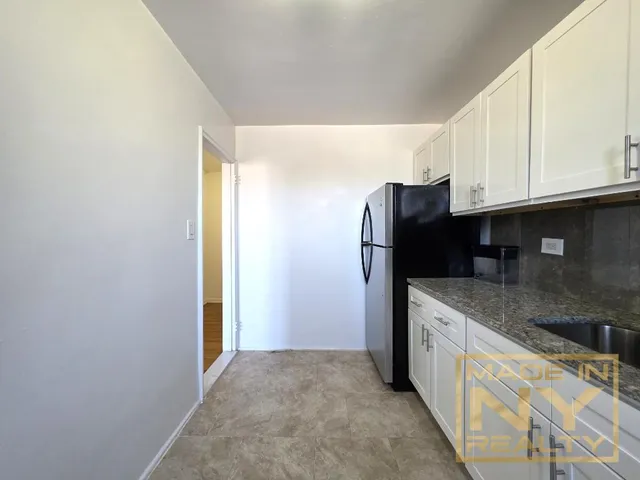 a kitchen with stainless steel appliances granite countertop a refrigerator and a stove