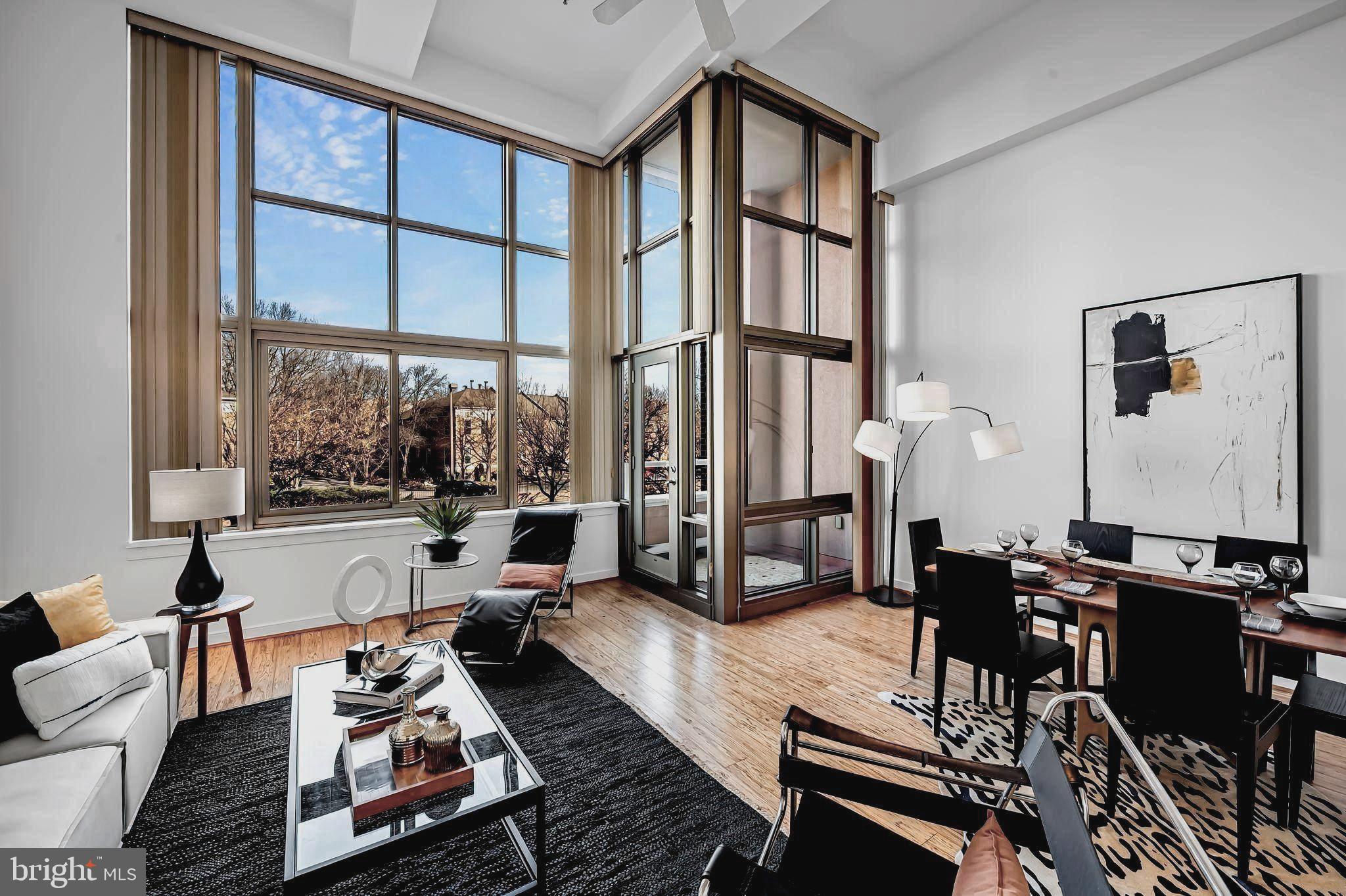 a living room with furniture large window and a table