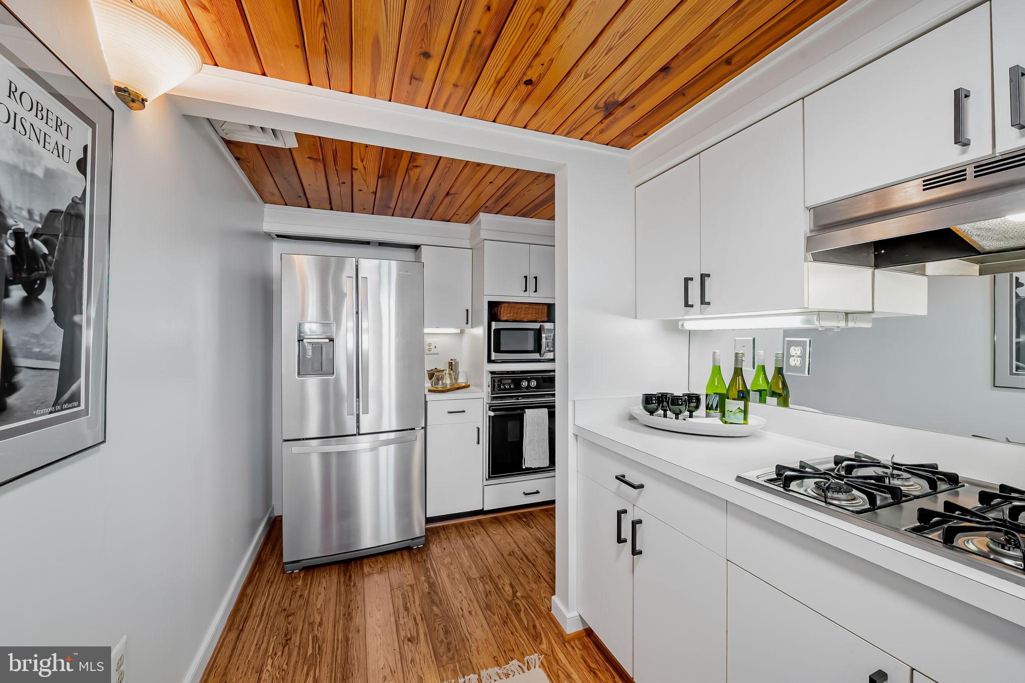 2901 Boston Street, Unit 204 Baltimore, MD 21224 - Photo 21 of 60 a kitchen with stainless steel appliances a stove a refrigerator and wooden floor