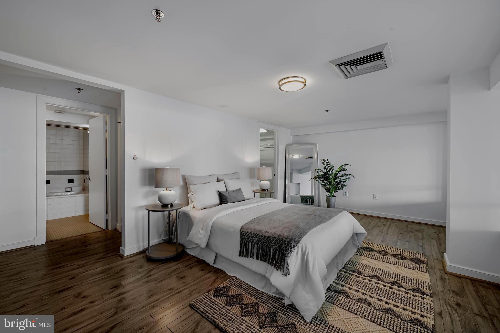 2901 Boston Street, Unit 204 Baltimore, MD 21224 - Photo 25 of 60 a bedroom with a bed and a potted plant