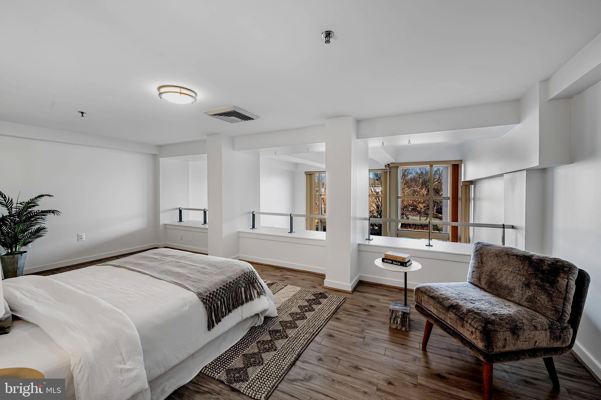 2901 Boston Street, Unit 204 Baltimore, MD 21224 - Photo 26 of 60 a bedroom with a bed and wooden floor