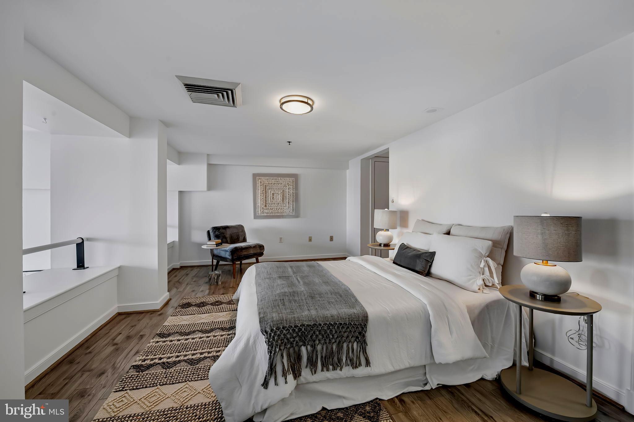 2901 Boston Street, Unit 204 Baltimore, MD 21224 - Photo 27 of 60 a bedroom with a bed and wooden floor