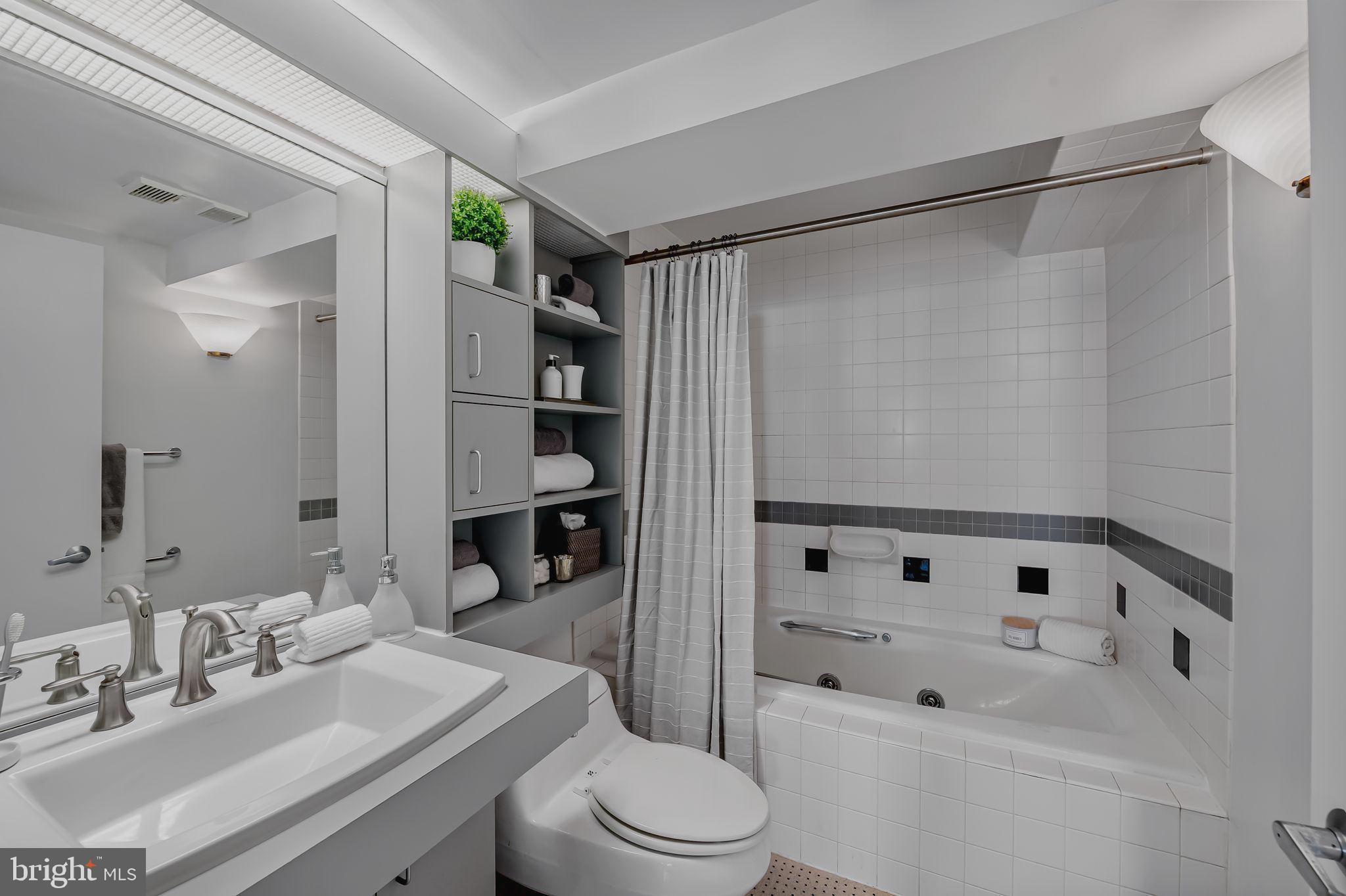 2901 Boston Street, Unit 204 Baltimore, MD 21224 - Photo 30 of 60 a bathroom with a sink toilet and shower