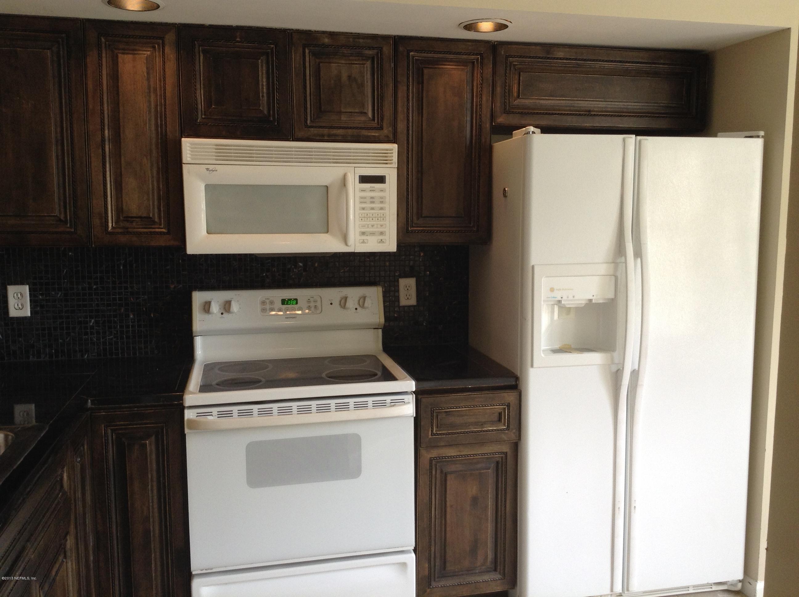 2426 Spring Vale Road Jacksonville, FL 32246 - Photo 8 of 10 a stove top oven sitting inside of a kitchen